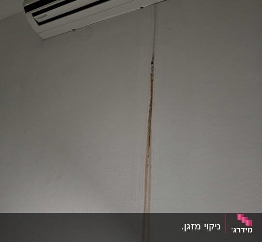 מזגן מותקן על קיר עם סימני נזילה